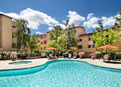 Thumbnail 18 of 21 - A swimming pool surrounded by chairs and umbrellas in a sunny day. at The Maddox Sunnyvale Apartments, Sunnyvale, CA, 94087