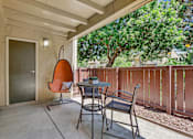 Thumbnail 5 of 90 - a patio with two chairs and a table and a door at Summerwood Apartments, Santa Clara