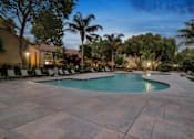 Thumbnail 34 of 90 - a large pool with chairs around it at night at Summerwood Apartments, Santa Clara, California