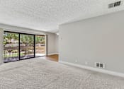 Thumbnail 17 of 90 - an empty living room with sliding glass doors to a balcony at Summerwood Apartments, Santa Clara, CA 95050