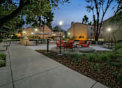 Thumbnail 31 of 90 - a courtyard with tables and chairs at night at Summerwood Apartments, Santa Clara, CA 95050