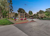 Thumbnail 13 of 90 - a street in front of a house with a driveway and a sign at Summerwood Apartments, Santa Clara, California