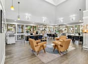 Thumbnail 32 of 90 - a living room with chairs and tables and a library at Summerwood Apartments, Santa Clara, CA