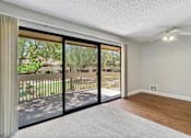 Thumbnail 22 of 90 - an empty living room with sliding glass doors to a balcony at Summerwood Apartments, California