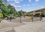 Thumbnail 72 of 90 - a fenced in play area with a playground in front of a building at Summerwood Apartments, Santa Clara, California