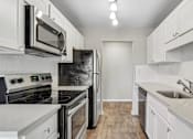 Thumbnail 87 of 90 - kitchen with white cabinets and stainless steel appliances at Summerwood Apartments, California