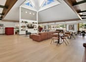 Thumbnail 89 of 90 - a large living room with a high ceiling and a dining room with tables and chairs at Summerwood Apartments, Santa Clara, CA 95050