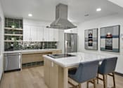 Thumbnail 86 of 90 - a kitchen with a large island and three chairs at Summerwood Apartments, Santa Clara, 95050