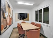 Thumbnail 84 of 90 - a conference room with a wooden table and chairs at Summerwood Apartments, Santa Clara