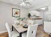 Thumbnail 37 of 90 - a dining room and kitchen with white cabinets and a table and chairs at Summerwood Apartments, California, 95050