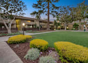 Thumbnail 6 of 90 - an exterior view of a building with green grass and trees at Summerwood Apartments, Santa Clara, California