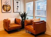 Thumbnail 12 of 32 - two leather chairs in a living room with two windows at Campbell West Apartments, Campbell, CA