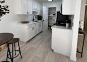 Thumbnail 1 of 32 - an open kitchen and dining area with white cabinets and a counter top at Campbell West Apartments, Campbell, CA 95008