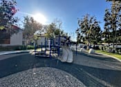 Thumbnail 24 of 44 - a playground with a slide in a park at The Bryant, Yorba Linda, CA 92887