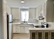 Thumbnail 10 of 31 - a kitchen with white cabinets and stainless steel appliances at The Flats on Addison, Sherman Oaks, 91423