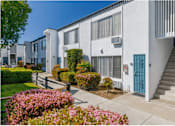Thumbnail 9 of 39 - a white apartment building with a staircase and a blue doorat The Arches Apartments, LLC, California