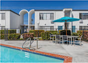 Thumbnail 7 of 39 - our apartments have a swimming pool and a patio with a table and umbrellaat The Arches Apartments, LLC, El Cajon California