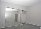 Thumbnail 12 of 19 - an empty living room with a large window and a mirrored closet  at The Marq Apartments LLC, Los Angeles, California