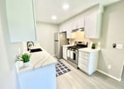 Thumbnail 16 of 18 - a kitchen with white cabinets and stainless steel appliances at BLVD Apartments LLC, Tarzana, 91356