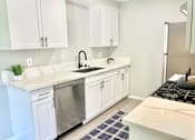 Thumbnail 15 of 18 - a kitchen with white cabinets and a stainless steel refrigerator at BLVD Apartments LLC, Tarzana, CA