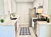 Thumbnail 1 of 18 - a kitchen with white cabinets and a stainless steel refrigerator at BLVD Apartments LLC, California