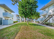 Thumbnail 9 of 18 - a grassy area between two buildings with trees in the middle at BLVD Apartments LLC, Tarzana, 91356