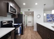 Thumbnail 1 of 44 - a kitchen with white counter tops and black appliances at The Bryant, Yorba Linda, CA 92887