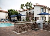Thumbnail 22 of 44 - a patio with a grill and a swimming pool at The Bryant, Yorba Linda California