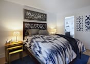 Thumbnail 12 of 44 - a bedroom with a bed and a nightstand with a lamp at The Bryant, Yorba Linda, 92887