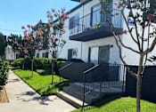 Thumbnail 4 of 39 - a white house with a sidewalk in front of it at Latitude Apartments at Mission Valley, San Diego, CA 92120