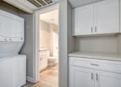 Thumbnail 20 of 27 - a laundry room with white cabinets and a white washer and dryer at La Jolla Blue, San Diego California