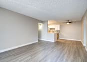 Thumbnail 18 of 27 - an empty living room and kitchen with wood flooring and a ceiling fan at La Jolla Blue, San Diego, CA