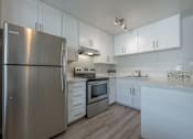 Thumbnail 24 of 24 - a white kitchen with stainless steel appliances and white cabinets at Napa Green Apartments LLC, California