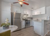 Thumbnail 12 of 24 - a kitchen with blue and red lights on the ceiling and white counters at Napa Green Apartments LLC, California, 94559