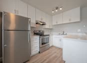 Thumbnail 15 of 24 - a kitchen with white cabinets and stainless steel appliances at Napa Green Apartments LLC, California