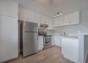 Thumbnail 5 of 24 - a white kitchen with stainless steel appliances and white cabinets at Napa Green Apartments LLC, Napa California