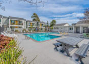 Thumbnail 9 of 24 - a swimming pool with a picnic table and chairs around it at Napa Green Apartments LLC, Napa, CA 
