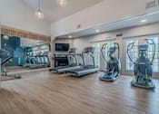 Thumbnail 2 of 24 - a gym with cardio machines and a fireplace at Napa Green Apartments LLC, Napa, 94559