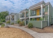 Thumbnail 4 of 24 - a row of green houses with yellow doors and a sidewalk at Napa Green Apartments LLC, California
