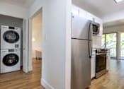 Thumbnail 19 of 83 - A white refrigerator is in a kitchen next to a washer and dryer at Summerwood Apartment , Santa Clara, CA