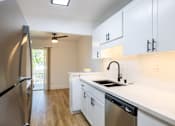 Thumbnail 16 of 83 - A kitchen with white cabinets and a stainless steel dishwasher at Summerwood Apartment , Santa Clara, California