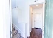 Thumbnail 40 of 45 - a view of the hallway of a home with stairs and a white door at The Vines at Riverpark, LLC, California, 93036