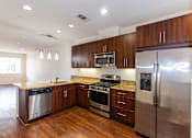 Thumbnail 41 of 45 - a kitchen with stainless steel appliances and wooden cabinets at The Vines at Riverpark, LLC, California, 93036