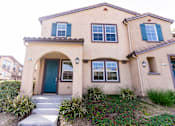 Thumbnail 28 of 45 - the front of a two story apartment with a blue door at The Vines at Riverpark, LLC, California, 93036