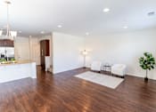Thumbnail 27 of 45 - an empty living room and kitchen with hard wood flooring and white walls at The Vines at Riverpark, LLC, California, 93036