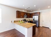 Thumbnail 33 of 45 - a kitchen with a granite counter top and a stainless steel refrigerator at The Vines at Riverpark, LLC, California, 93036