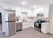 Thumbnail 26 of 31 - a white kitchen with stainless steel appliances and white cabinets at The Flats on Addison, Sherman Oaks, CA 91423