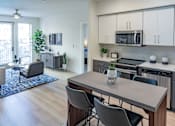 Thumbnail 71 of 78 - A modern kitchen with a dining table and chairs.