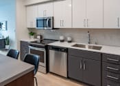 Thumbnail 69 of 78 - A modern kitchen with a dining table and chairs.