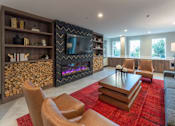 Thumbnail 54 of 78 - A modern living room with a fireplace and a television.